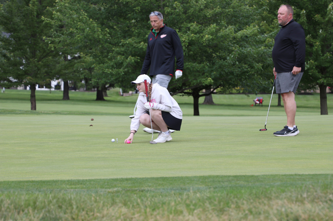 Woman placing ball on the green